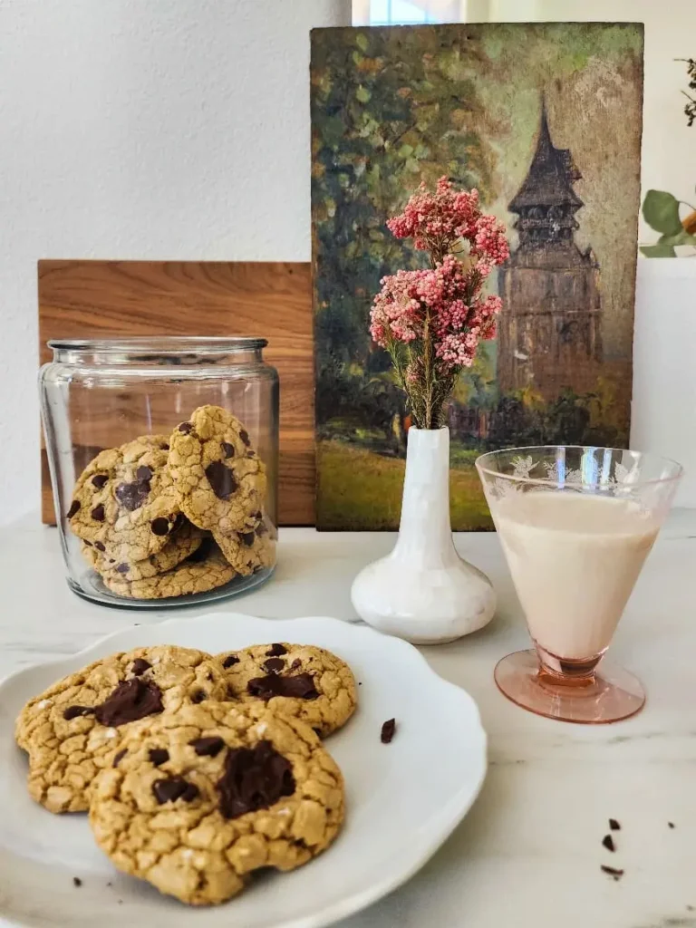 A plate of gluten free chocolate chip cookies and a glass of dairy free milk make for a delicious snack.