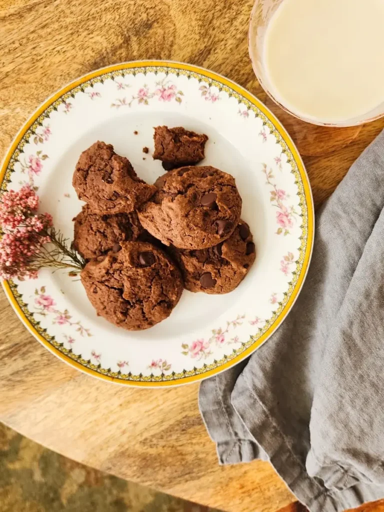 Chocolate peanut butter cookies on a china plate and a glass of milk