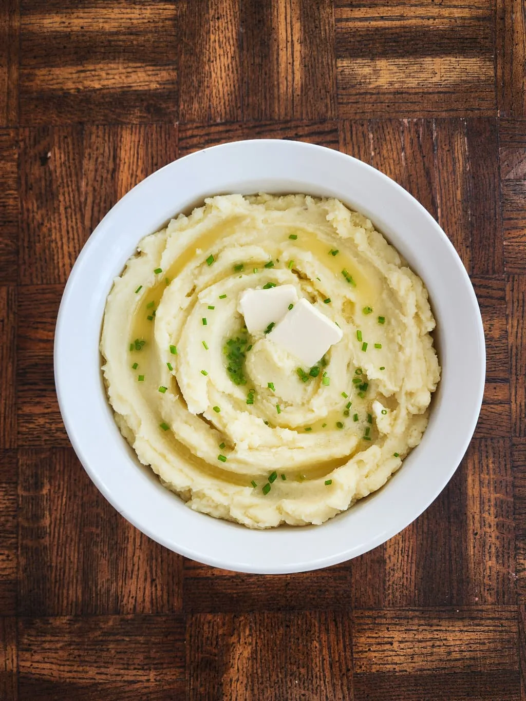 bowl of dairy free mashed potatoes with dairy free butter and chives on top