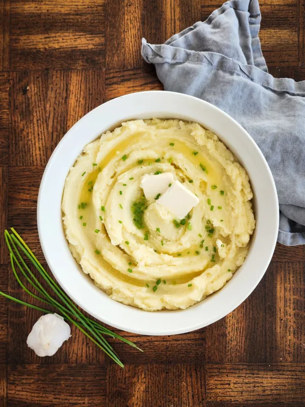 bowl of dairy free mashed potatoes with dairy free butter and chives on top