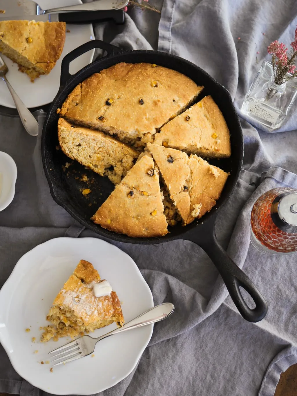 Gluten free cornbread in a cast iron skillet with a plate of cornbread