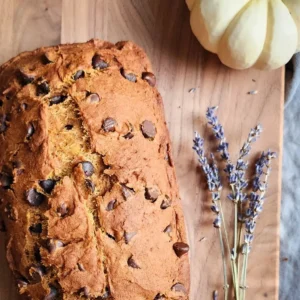 sliced gluten free pumpkin bread with chocolate chips on a wooden cutting board