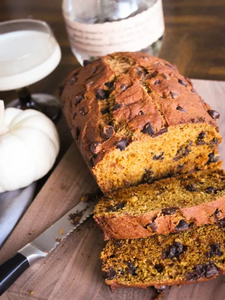 sliced gluten free pumpkin bread with chocolate chips on a wooden cutting board
