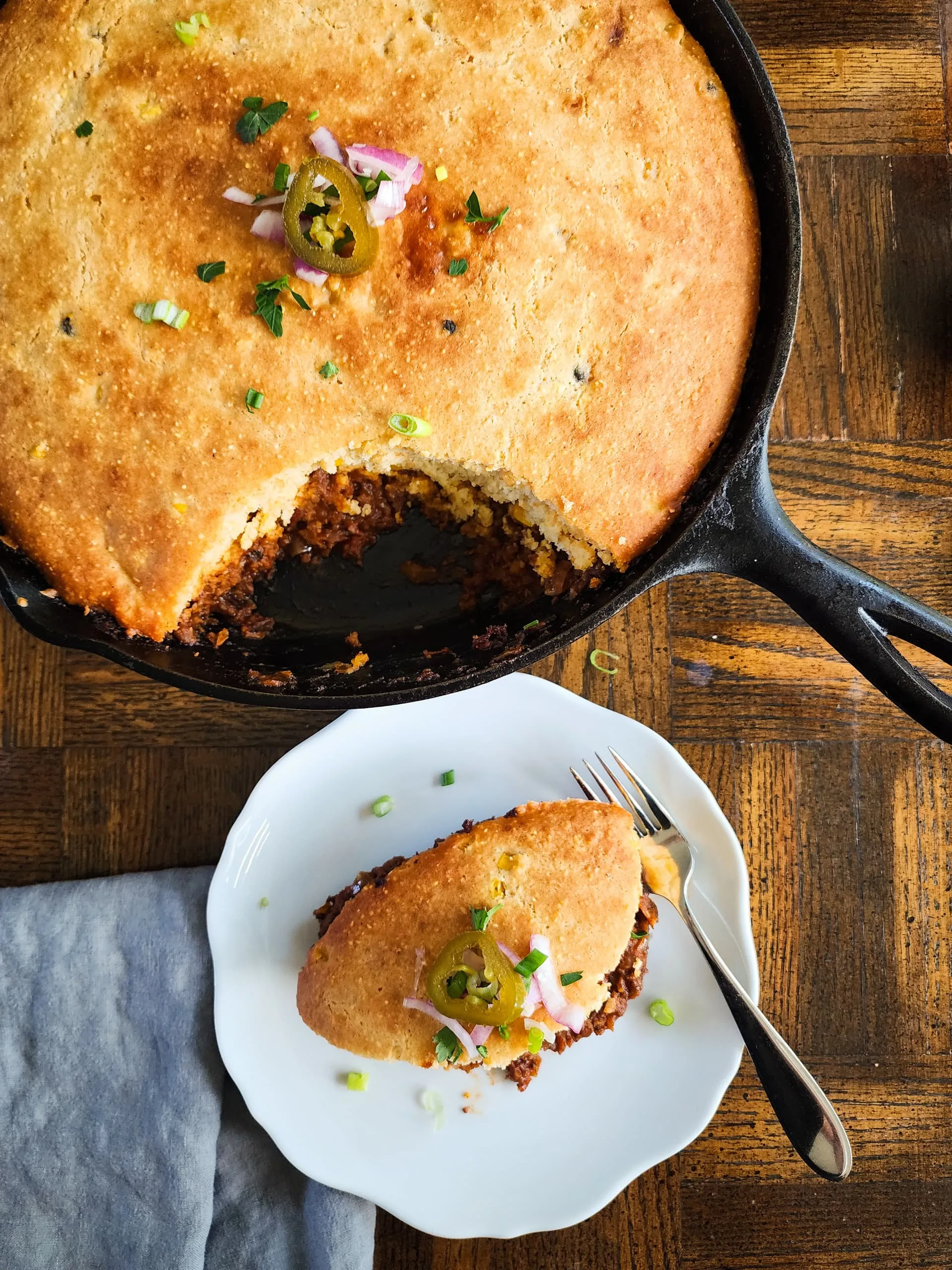 a plate of chili cornbread pie and the skillet - rich, hearty, and delicious