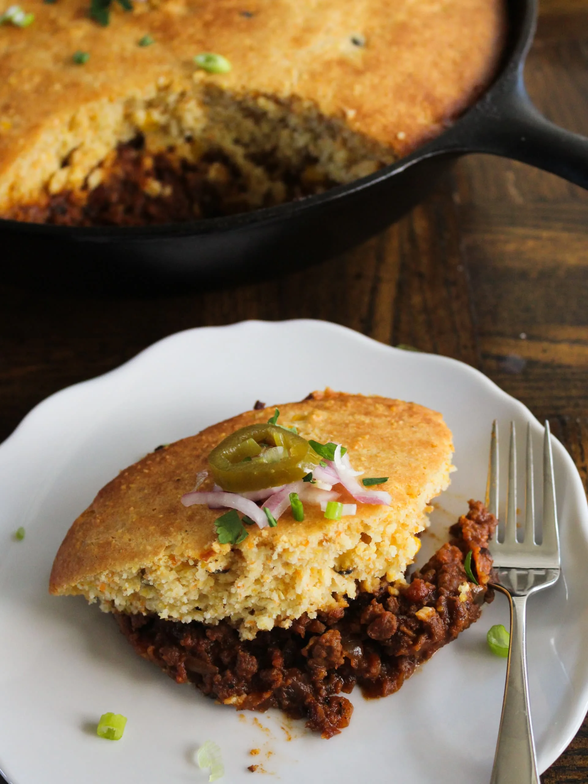 a piece of chili cornbread pie with all the fixins - rich, hearty, and delicious