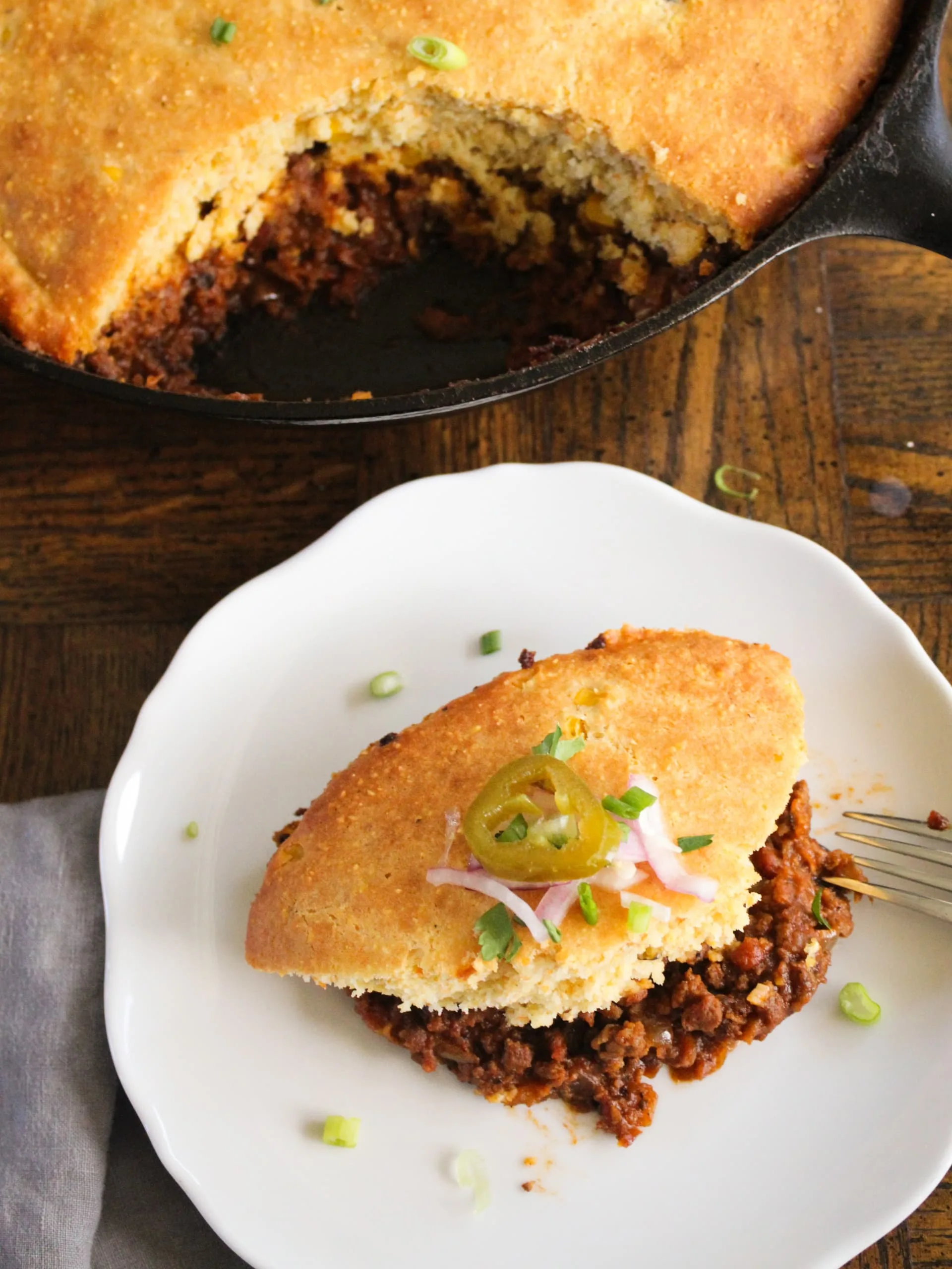 a piece of chili cornbread pie with all the fixins - rich, hearty, and delicious