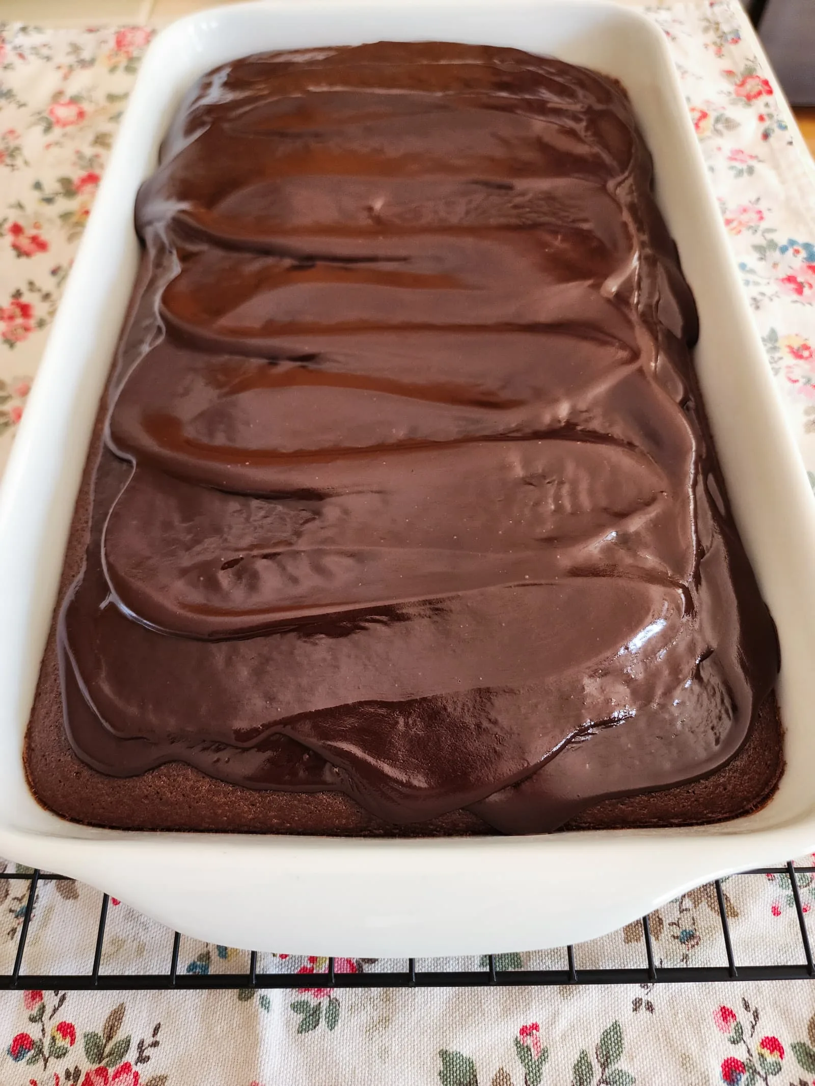 A pan of gluten free chocolate cake on a floral background