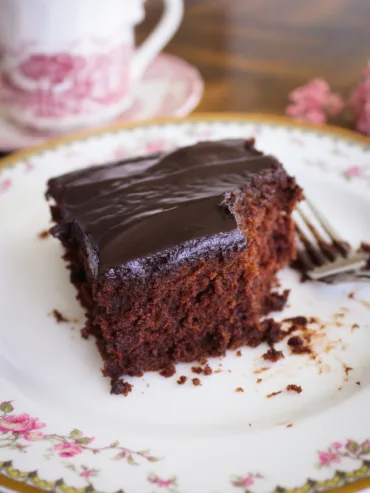 A piece of gluten free chocolate cake on a vintage china plate