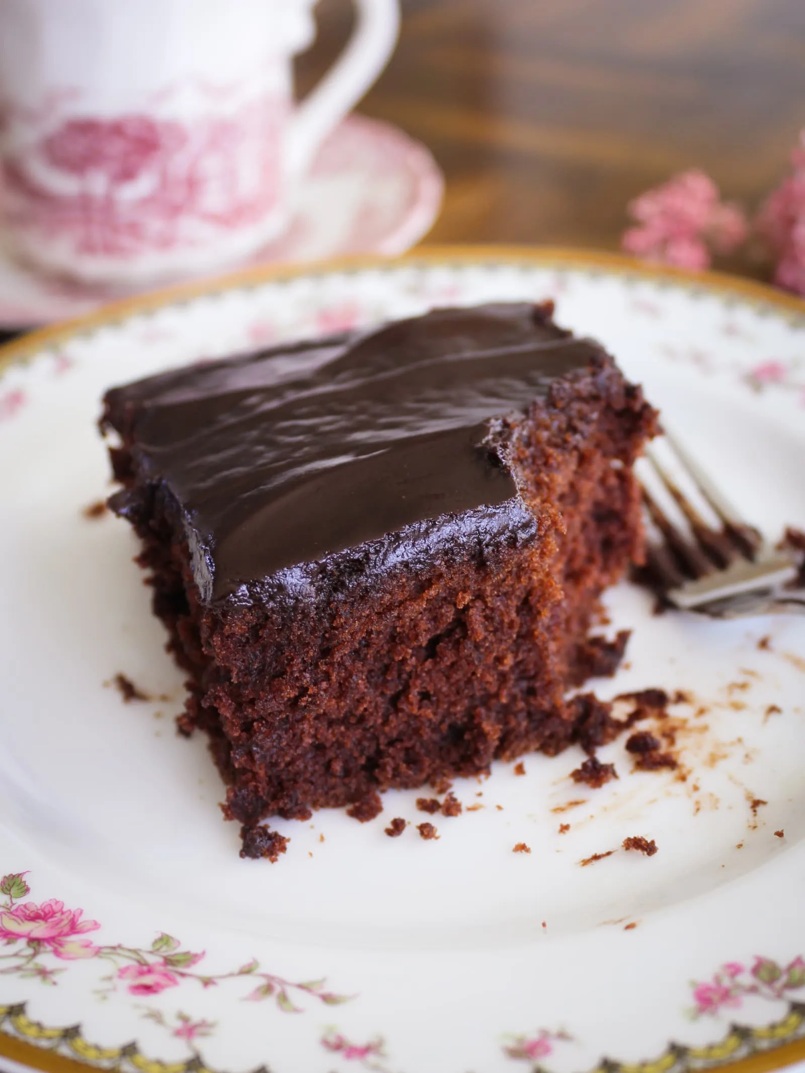 A piece of gluten free chocolate cake on a vintage china plate