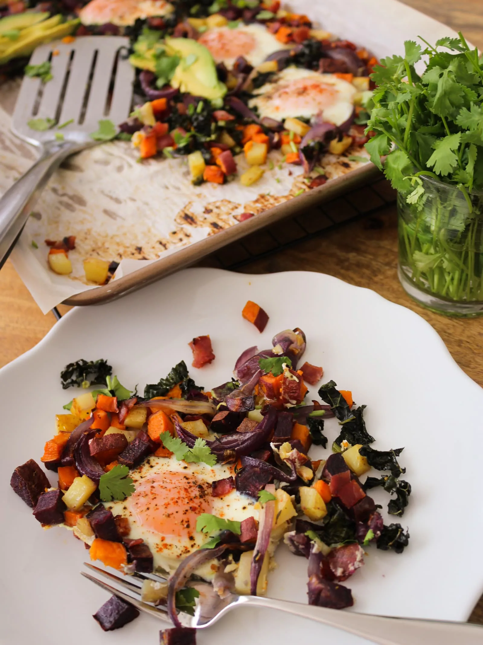 This potato and sweet potato hash recipe features crispy ham, eggs, and fresh greens. Perfect for a slow weekend morning or a home full of guests, or any time you want a hearty breakfast or easy-to-pull-together dinner. Naturally gluten free and dairy free.