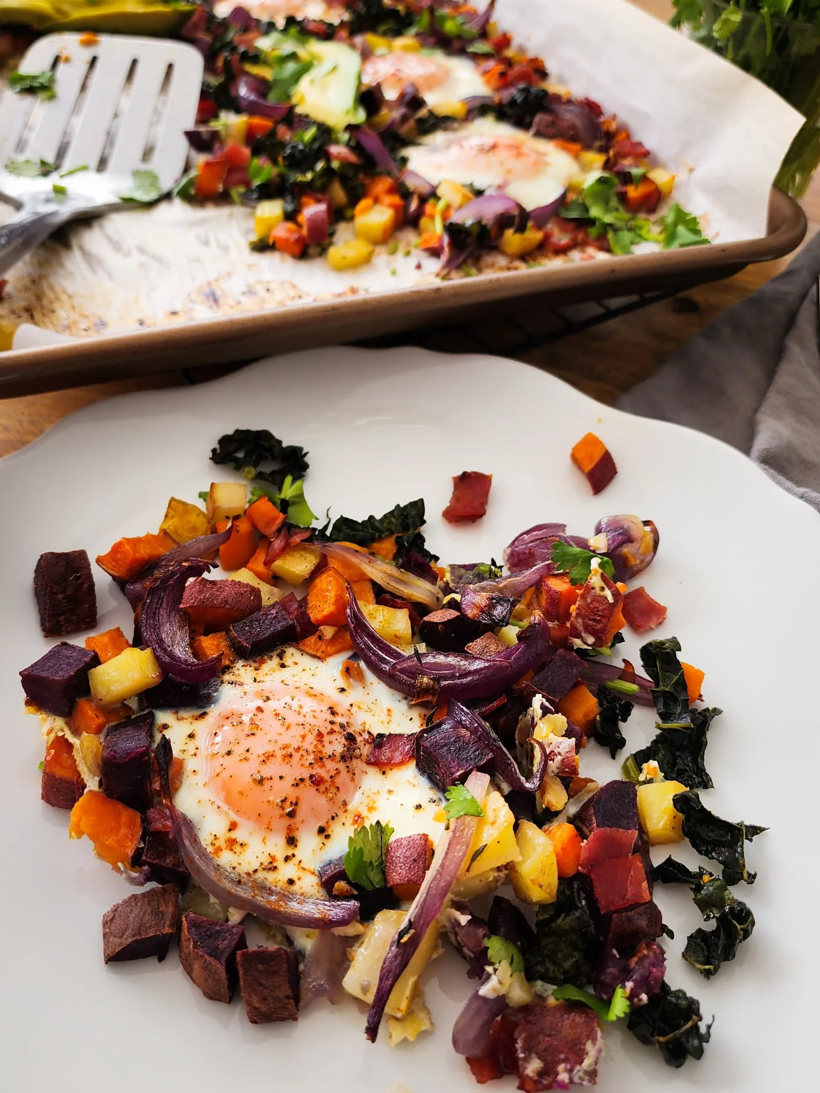 This potato and sweet potato hash recipe features crispy ham, eggs, and fresh greens. Perfect for a slow weekend morning or a home full of guests, or any time you want a hearty breakfast or easy-to-pull-together dinner. Naturally gluten free and dairy free.