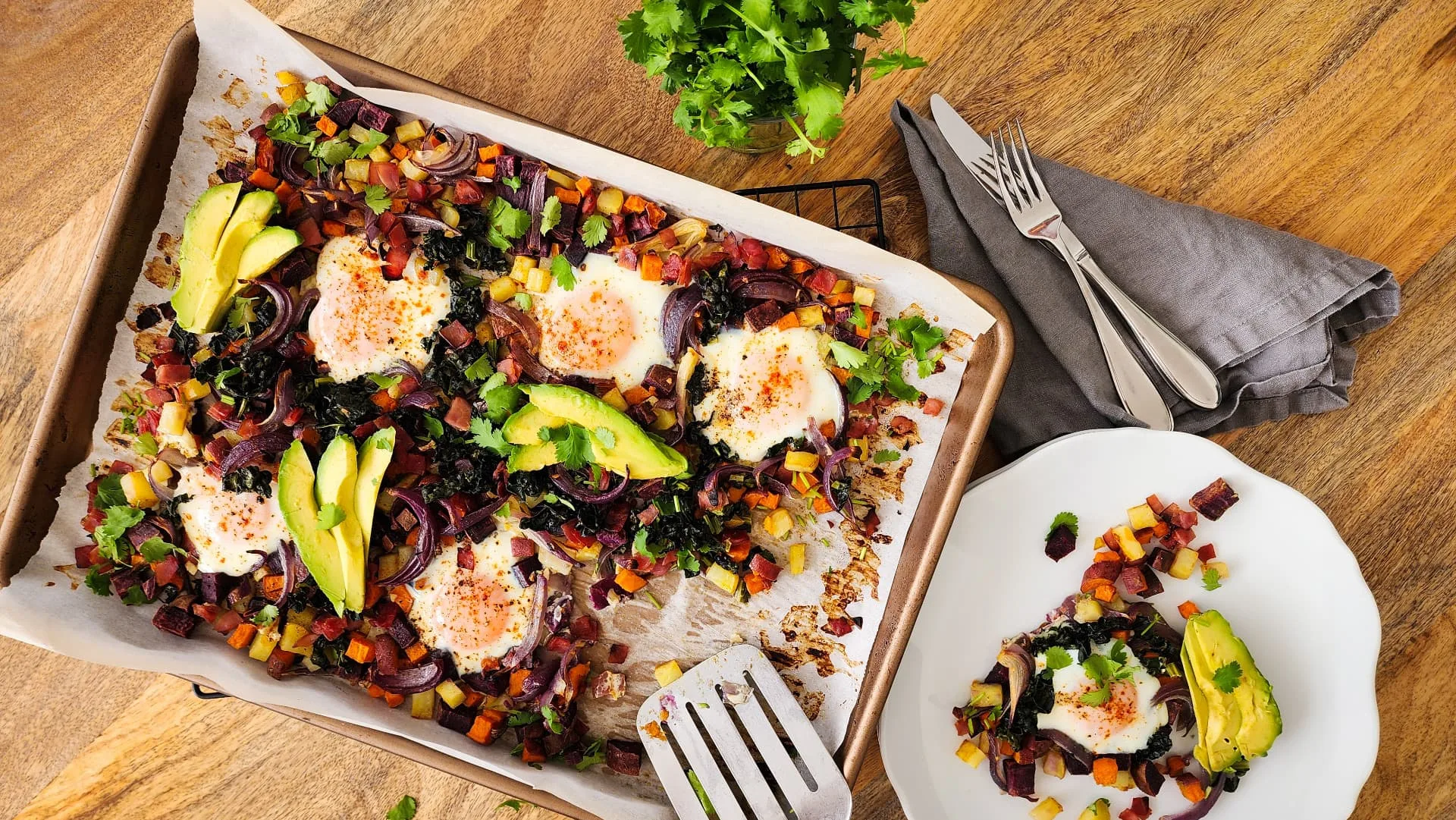 This potato and sweet potato hash recipe features crispy ham, eggs, and fresh greens. Perfect for a slow weekend morning or a home full of guests, or any time you want a hearty breakfast or easy-to-pull-together dinner. Naturally gluten free and dairy free.